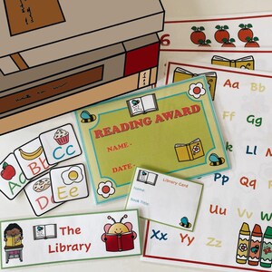 May include: A colorful reading award certificate with a bee and book design. The certificate has spaces for the recipient's name and date. There are also several alphabet flashcards and a library card.