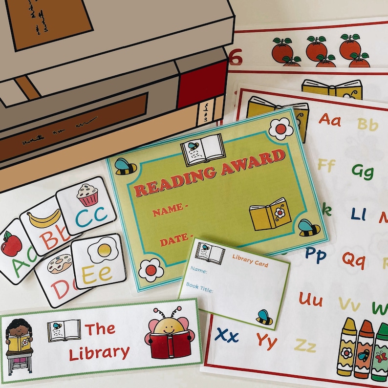 May include: A colorful reading award certificate with a bee and book design. The certificate has spaces for the recipient's name and date. There are also several alphabet flashcards and a library card.
