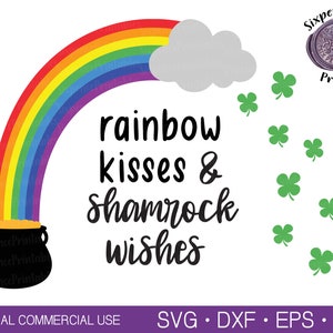 Può includere: Un arcobaleno con un pentolone d'oro alla fine, una nuvola e trifogli che cadono dal cielo. Il testo dice "rainbow kisses & shamrock wishes".