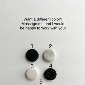 May include: A selection of five small, round, colored objects. The colors include black, sparkly white, light pink, black with glitter, and a light beige. Text above reads, "Want a different color? Message me and I would be happy to work with you!"