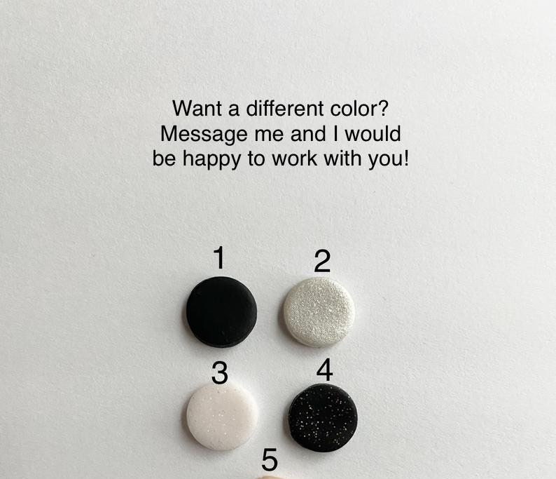 May include: A selection of five small, round, colored objects. The colors include black, sparkly white, light pink, black with glitter, and a light beige. Text above reads, "Want a different color? Message me and I would be happy to work with you!"