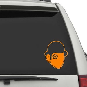 May include: Orange vinyl decal of a character from the movie "A Clockwork Orange". The character is wearing a bowler hat and has a gear for an eye.