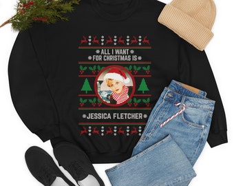 May include: Black Christmas jumper with a red and green pattern. The jumper features a photo of a woman with the text "All I Want For Christmas Is" and "Jessica Fletcher".