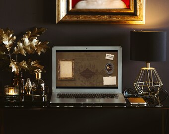 May include: A laptop computer with a dark brown background showing a map of Hogwarts from the Harry Potter series. The map is titled "Hogwarts, Wormtail's Passport & Prince". The laptop is on a black desk with a gold framed picture, a gold lamp, and a vase with gold leaves.