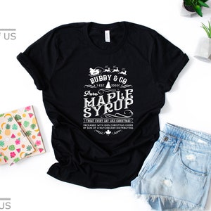 May include: Black t-shirt with a white graphic design that says "Bubby & Co. Est. 2021 Pure Maple Syrup Treat Every Day Like Christmas Packaged with Holiday Cheer by Son of a Nutcracker Distributing".