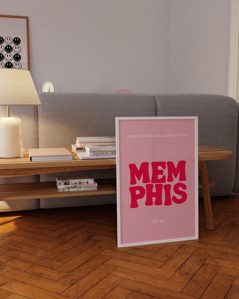 May include: Pink and white framed print with the text "HOME OF BLUES, SOUL & ROCK 'N ROLL" and "MEMPHIS" in large pink letters. The text "EST. 1819" is below the word "MEMPHIS".