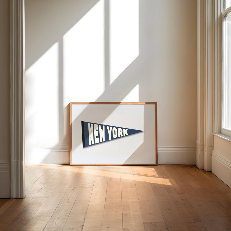 Puede incluir: Una impresi&oacute;n enmarcada de un bander&iacute;n azul con las palabras "NEW YORK" en letras blancas.