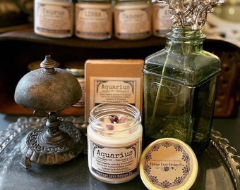 Pode incluir: Um frasco de vidro com uma vela branca e um rótulo castanho que diz "Aquarius January 20 - February 18 Intelligent, quirky & original.  You are independent, clever,  loyal & friendly, but can be distant & often detached. Vintage Luxe Design Co."
