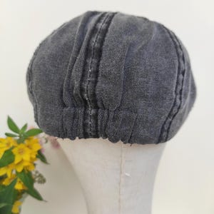 Peut inclure: Casquette de style gavroche de couleur gris fonc&eacute;, avec une couronne arrondie et une courte visi&egrave;re rigide. La casquette est faite d'un tissu textur&eacute; et pr&eacute;sente des d&eacute;tails de couture verticaux. L'&eacute;lastique &agrave; la base assure un ajustement confortable.