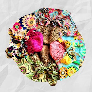 K&ouml;nnte beinhalten: Eine bunte Auswahl an Stoffresten und geh&auml;kelten H&uuml;ten, die in einem Kreis angeordnet sind. Die Stoffreste zeigen verschiedene florale und geometrische Muster in den Farben Rosa, Blau, Gelb, Gr&uuml;n und Braun.