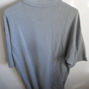 May include: A gray short-sleeved polo shirt with a ribbed texture.