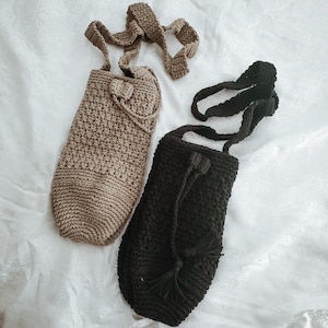 Peut inclure: Deux sacs en crochet, l'un beige et l'autre noir, avec de longues lani&egrave;res. Les deux sacs ont un design nou&eacute;.