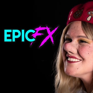 Könnte beinhalten: Eine Frau mit blonden Haaren trägt eine rote Baskenmütze mit gestickten Pilzen und einem Bären. Sie lächelt und schaut nach rechts. Der Text "EPIC FX" ist im Hintergrund.