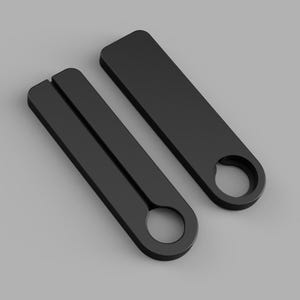 May include: Two matte black, elongated rectangular objects with rounded ends. Each piece features a circular cutout at one end and a straight, narrow slit running down the center of the length, creating a symmetrical, functional design.