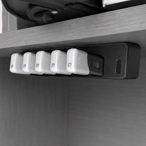 May include: A black rectangular mounting bracket attached to the underside of a shelf, holding five white and black USB flash drives in a horizontal row. The bracket features a slim profile with a dedicated slot for each individual flash drive.