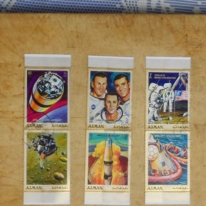 Può includere: Sei francobolli vintage di Ajman, Emirati Arabi Uniti, con immagini relative alla missione Apollo 11. I francobolli raffigurano astronauti, un modulo lunare e un lancio di razzi.