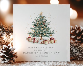 May include: A square white greeting card featuring a watercolor illustration of a decorated Christmas tree with gold and red ornaments, a star topper, and wrapped gifts underneath. The text reads: MERRY CHRISTMAS TO A VERY SPECIAL DAUGHTER & SON-IN-LAW Sue & Richard.