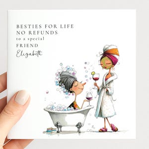 May include: A square greeting card featuring a cartoon illustration of two friends, one in a bubble bath and one in a bathrobe with a face mask, holding wine glasses. The text reads: BESTIES FOR LIFE NO REFUNDS to a special friend Elizabeth.