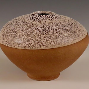 Könnte beinhalten: Eine Keramikvase mit einer weißen Craquelé-Glasur auf der oberen Hälfte und einer braunen Glasur auf der unteren Hälfte.