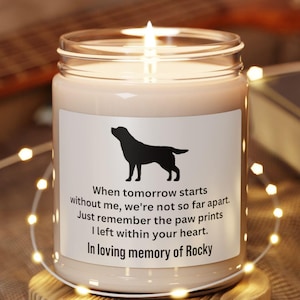 May include: A white candle with a black silhouette of a dog and the text "When tomorrow starts without me, we're not so far apart. Just remember the paw prints I left within your heart. In loving memory of Rocky" on the label.