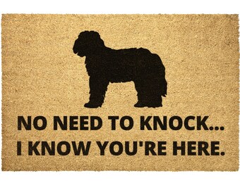May include: A brown coir doormat with a black silhouette of a dog and the text "NO NEED TO KNOCK... I KNOW YOU'RE HERE."