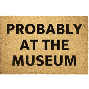 May include: A brown doormat with the text "PROBABLY AT THE MUSEUM" in black lettering.