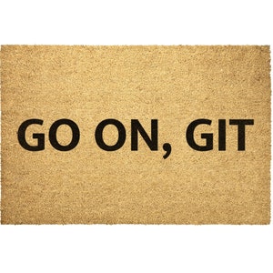 May include: A brown coir doormat with the text "GO ON, GIT" in black lettering.