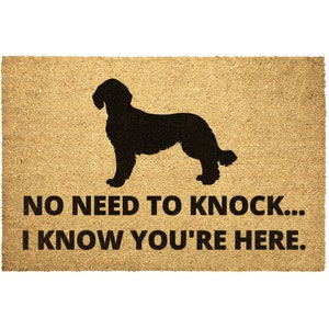 May include: A brown coir doormat with a black silhouette of a dog and the text "NO NEED TO KNOCK... I KNOW YOU'RE HERE."