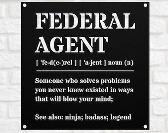 May include: Black metal sign with white text that reads "FEDERAL AGENT" and defines the word as "Someone who solves problems you never knew existed in ways that will blow your mind; See also: ninja; badass; legend".