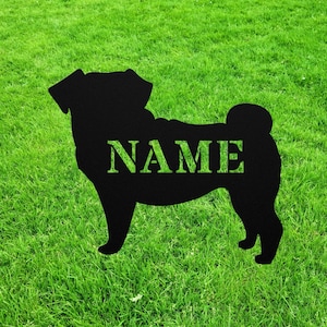 May include: Black silhouette of a pug dog with the word "NAME" printed on its back, set against a green grassy background.