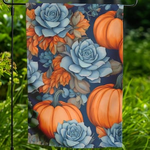 May include: A garden flag with a blue and orange floral pattern. The pattern features succulents and pumpkins. The background is a dark blue.
