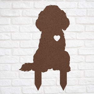 May include: Brown metal silhouette of a dog with a white heart on its chest. The dog is sitting with its tail curled around its legs. The silhouette is attached to two metal stakes.