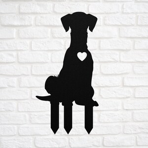 May include: Black metal silhouette of a dog sitting on three stakes. The dog has a heart on its chest.