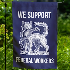 May include: A blue garden flag with white text that reads "We Support Federal Workers". A white illustration of a cat holding a snake in its mouth is in the center of the flag.