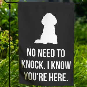 May include: Black garden flag with a white silhouette of a dog sitting. The text "NO NEED TO KNOCK. I KNOW YOU'RE HERE." is printed in white.
