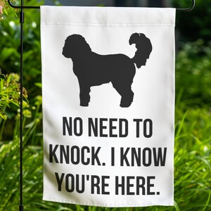 May include: White garden flag with a black silhouette of a dog and the text "NO NEED TO KNOCK. I KNOW YOU'RE HERE."
