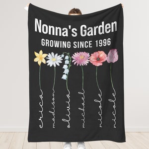 May include: Black blanket with the text "Nonna's Garden GROWING SINCE 1996". Features watercolor flowers and names: Erica, Madison, Olivia, Michael, Nicole, and Nicole.