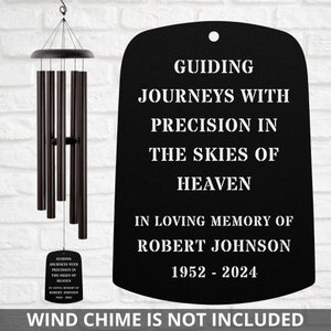 May include: Black metal wind chime plaque with white text that reads "Guiding Journeys With Precision In The Skies Of Heaven In Loving Memory Of Robert Johnson 1952-2024". Wind chime is not included.