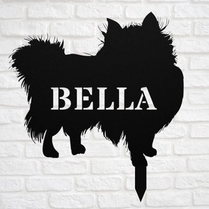 May include: Black metal silhouette of a dog with the name "BELLA" written on it. The silhouette is attached to a metal stake for planting in the ground.