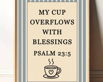 May include: Framed wall art with the text "MY CUP OVERFLOWS WITH BLESSINGS PSALM 23:5" in black font. The artwork features a coffee cup with a heart design and steam. The frame is light brown, and the background has blue and white vertical stripes.