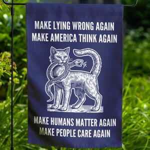 May include: A blue garden flag with white text and a white illustration of a cat holding a snake in its mouth. The text reads "Make Lying Wrong Again", "Make America Think Again", "Make Humans Matter Again", and "Make People Care Again".