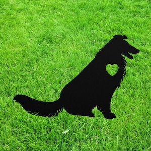 May include: Black silhouette of a dog with a heart cutout in its chest, set against a green grassy background.