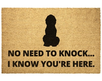 May include: A brown coir doormat with a black silhouette of a dog and the text "NO NEED TO KNOCK... I KNOW YOU'RE HERE."