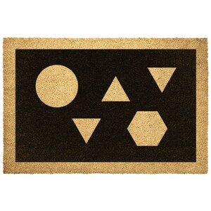 May include: A brown coir doormat with a black border and a design of a circle, triangle, and hexagon in beige.