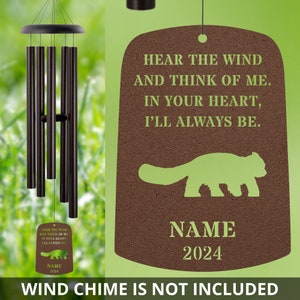 May include: A brown metal memorial wind chime tag with a green silhouette of a red panda. The tag has the text "Hear the wind and think of me. In your heart, I'll always be." and a space for a name and year. The text "Wind chime is not included" is at the bottom of the image.