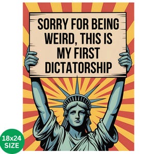 May include: A poster featuring the Statue of Liberty holding a sign with the text "SORRY FOR BEING WEIRD, THIS IS MY FIRST DICTATORSHIP." The background has a red and yellow burst design. The poster size is 18x24 inches.