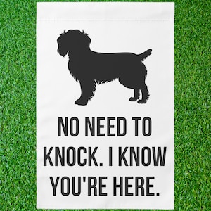 May include: A white garden flag with a black silhouette of a dog and the text "NO NEED TO KNOCK. I KNOW YOU'RE HERE."