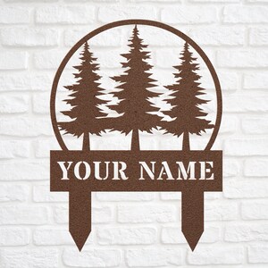 May include: A brown metal garden stake with three pine trees in a circle and the text "YOUR NAME" on a rectangular plaque.