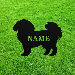 May include: Black silhouette of a dog with the word "NAME" in white text on a green grassy background.