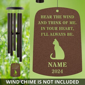 May include: A brown wooden plaque with a green cat silhouette and the text "Hear the wind and think of me. In your heart, I'll always be."  The plaque also includes the text "NAME 2024".